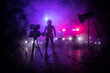 © zef art - Action movie concept. Police cars and miniature movie set on dark toned background with fog. Police car chasing a car at night. Scene of crime accident.