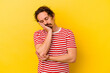 © Asier - Young caucasian man isolated on yellow background who is bored, fatigued and need a relax day.