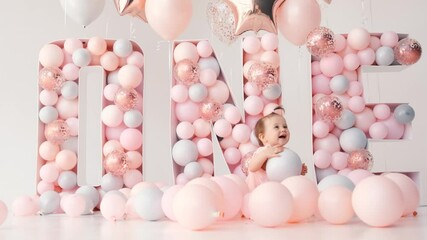 little cute girl smiling with colorful balloons white and pink in birthday decoration