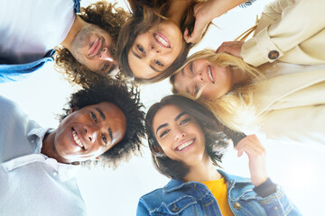 Multi-ethnic group of friends with their heads together in a circle.