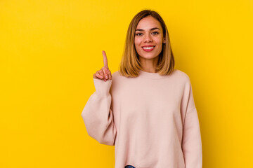 Young caucasian skinny woman isolated on yellow background showing number one with finger.