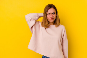 Young caucasian skinny woman isolated on yellow background touching back of head, thinking and making a choice.