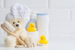 © Юлия Клюева - Baby bath accessories, baby care, a yellow bear with a towel on its head, a brush and bottles of shampoo.