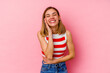 © Asier - Young caucasian woman isolated on pink background laughs happily and has fun keeping hands on stomach.