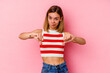 © Asier - Young caucasian woman isolated on pink background showing thumb down, disappointment concept.