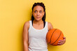 Young african american woman playing basketball isolated on yellow background confused, feels doubtful and unsure.