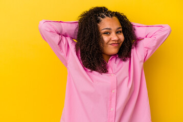 Young african american woman isolated on yellow background touching back of head, thinking and making a choice.