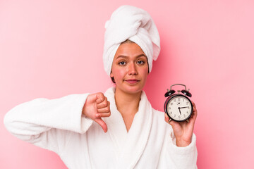 Poster - Young venezuelan woman late for work isolated on pink background showing a dislike gesture, thumbs down. Disagreement concept.