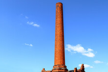 Old Tall Red Brick Factory Chimney With Blue Sky Background