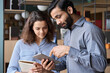 © insta_photos - Diverse friendly coworkers colleagues indian male manager and latin female employee talking in office space using tablet device. Effective management, teaching and mentoring new employee concept.