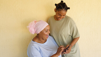 Mother and daughter laughing at something on the phone