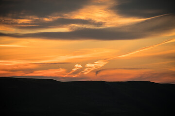 Wall Mural - Colorful sunset over the mountain hills. Beautiful clouds flying over the lake near mountains. Evening time shot over the clouds. Baku, Azerbaijan.