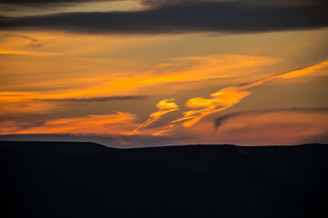 Wall Mural - Colorful sunset over the mountain hills. Beautiful clouds flying over the lake near mountains. Evening time shot over the clouds. Baku, Azerbaijan.