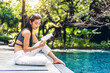 © Art_Photo - Portrait of beauty asian woman read the paper book work study and looking at page magazine while sitting in swimming pool on summer travel vacation relaxing at resort spa