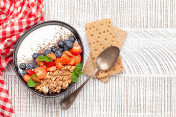 Wall Mural - Healthy breakfast with bowl of granola, yogurt and fresh berries