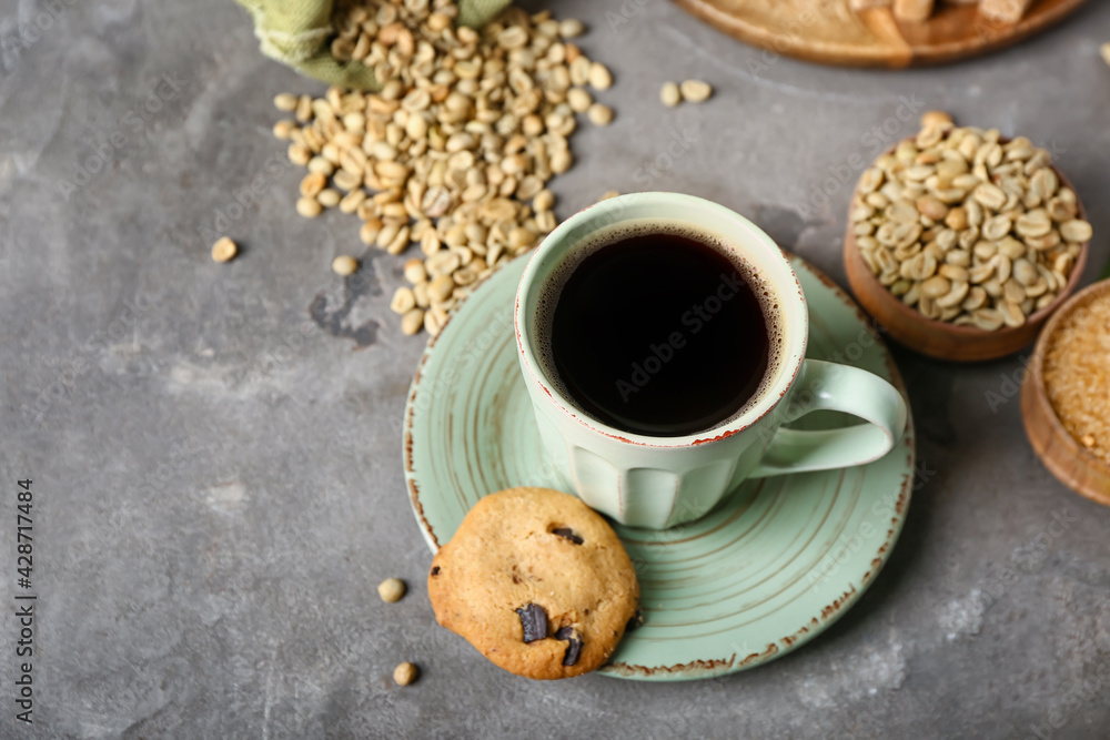 Composition with cup of tasty coffee and beans on grey background