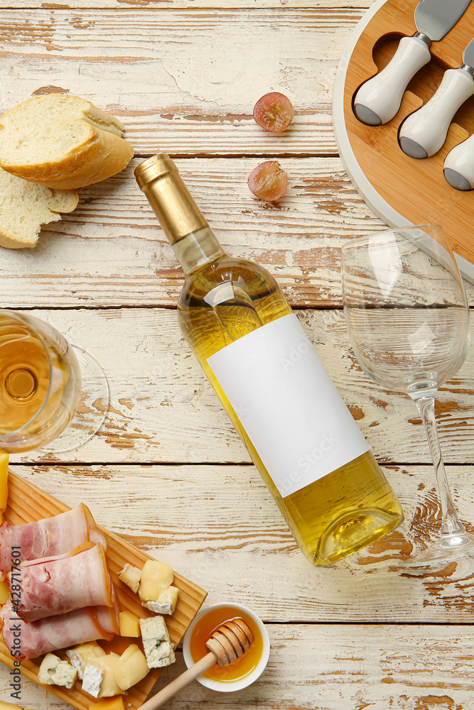 Composition with bottle of wine on white wooden background
