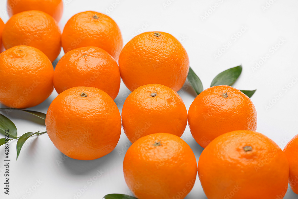 Composition with sweet tangerines and leaves on white background, closeup