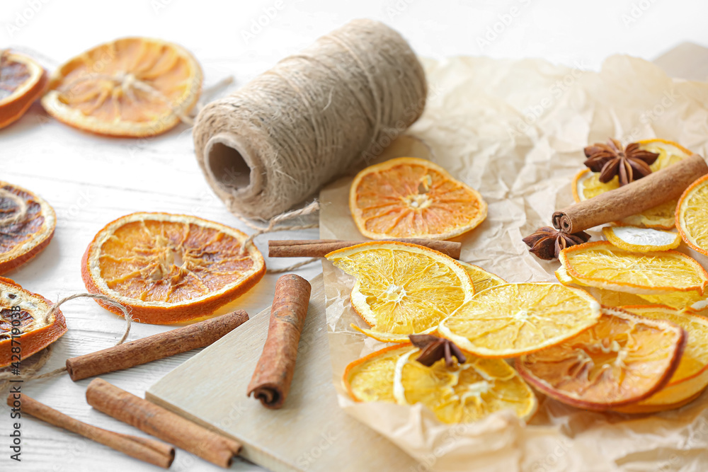 Dried orange slices and spices on light background