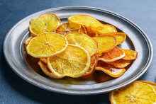 Plate With Dried Citrus Fruits On Color Background