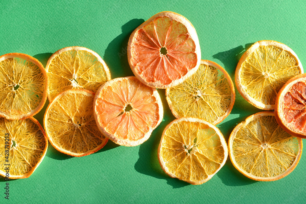 Dried citrus fruits on color background