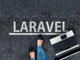 Wall Mural - laravel php framework programming language. woman legs in sneakers standing next to laptop and word 