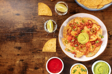 Wall Mural - Nachos, Mexican tortilla chips, shot from the top on a rustic wooden background