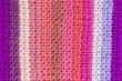 striped background of tunisian crochet fabric in basic stitch in shades of pink and purple