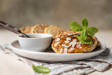 Wall Mural - Healthy oat pancakes with jam, nuts and mint on ceramic plate. Vegan breakfast food.