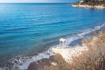 Wall Mural - Beautiful small white bench on the Governor's beach near Limassol, Cyprus.