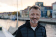 © contrastwerkstatt - Smiling happy friendly middle-aged man at the waterfront