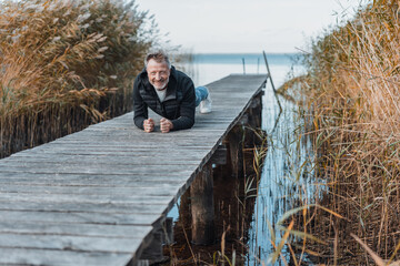 Wall Mural - Happy healthy man working out n a wooden jetty or boardwalk