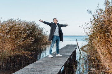 Wall Mural - Blissful man celebrating the freedom of nature with open arms