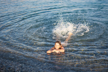 Wall Mural - the woman swims relaxed in the transparent water