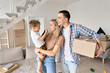 © insta_photos - Happy family couple new home owners holding toddler kid child son and cardboard box on moving day standing in modern living room. Relocation, mortgage, real estate property purchase, removal.