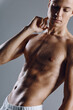© SHOTPRIME STUDIO - man with a pumped-up torso on a gray background posing biceps bodybuilder model