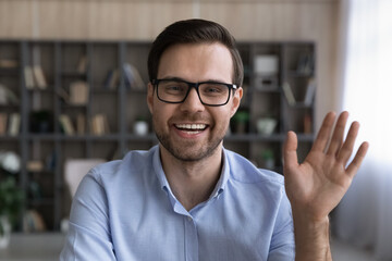Wall Mural - close up profile screen view picture of smiling young caucasian man in glasses wave greet talk on vi