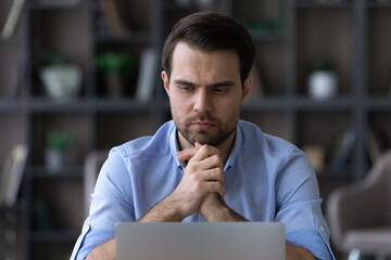 Sticker - Pensive young Caucasian man work on laptop in home office look at screen thinking pondering of problem solution. Thoughtful male employee worker busy using computer make decision. Technology concept.