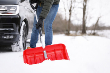 Wall Mural - Man removing snow with shovel near car outdoors on winter day, closeup