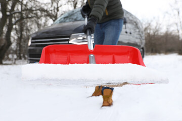 Wall Mural - Man removing snow with shovel near car outdoors on winter day, closeup