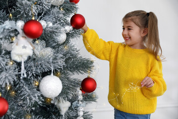 Canvas Print - Cute little girl decorating Christmas tree at home