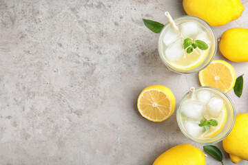 Canvas Print - Cool freshly made lemonade and fruits on grey table, flat lay. Space for text