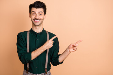 Poster - Photo of happy smiling good mood cheerful gentleman point finger copyspace advertise product isolated on beige color background