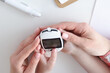 © H_Ko - Hands of mom and little daughter holding glucometer closeup
