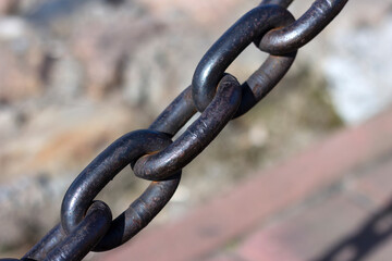 Heavy cast iron chain with rust. Protective fence on the bank of the Neva River in St. Petersburg.