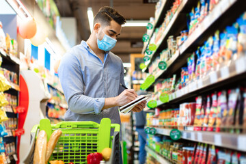 Wall Mural - Arabic Man Taking Notes In Groceries Shopping List In Supermarket