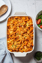 Baked pasta with chicken and cheese in oven dish, gray background, top view. Italian cuisine concept.