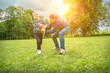© Andrii IURLOV - Father and son playing football, Father's day, Playful Man teaching Boy rugby outdoors in sunny day at public park. Family sports weekend.