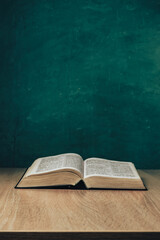 Aufkleber - Open holy bible on a  wooden table. Beautiful green wall background.