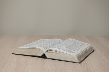 Aufkleber - Open holy bible on a  wooden table. Beautiful white wall background.